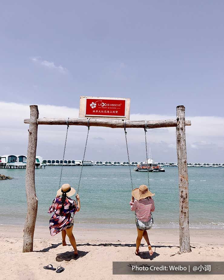 Two womens sitting on a swing at the beach in Lexis Hibiscus
