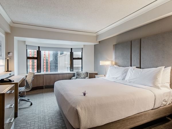 Hotel guestroom with king bed, desk and TV