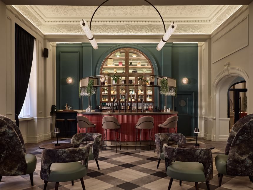 Elegant Gott\'s Bar with plush seating and arched shelving, featuring exposed bottles at The Met Hotel Leeds, England