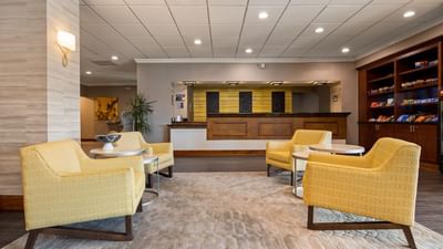 Hotels in Louisville of Cottonwood Louisville, lobby featuring yellow armchairs and reception desk beside snack pantry	
