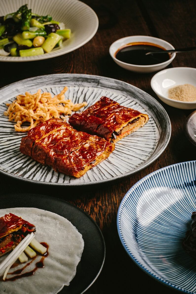 Plated dishes and sauces on a table at Paradox Vancouver.