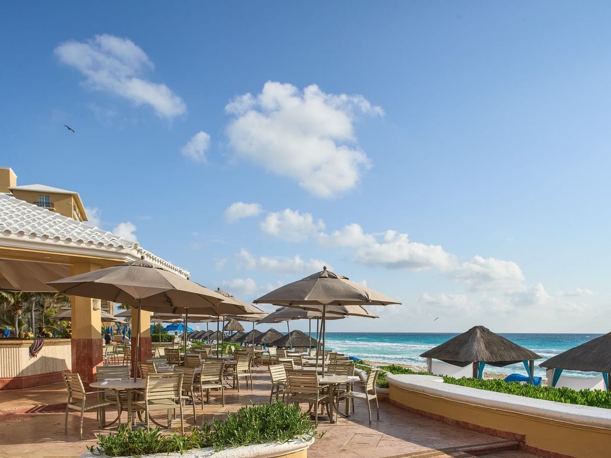 Tables arranged in The Caribe Bar & Grill with a sea view at Kempinski Hotel Cancún