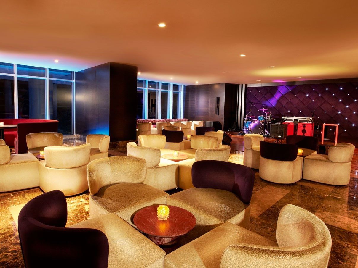 A cozy lounge area with couches and chairs arranged in Stage Bar at Megapolis Hotel Panama 