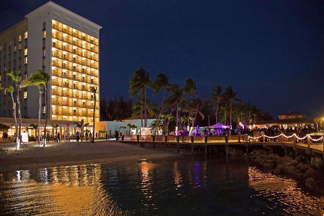 Bright tower by a wooden pier under a dark sky surrounding a night party at Warwick Paradise Island Bahamas