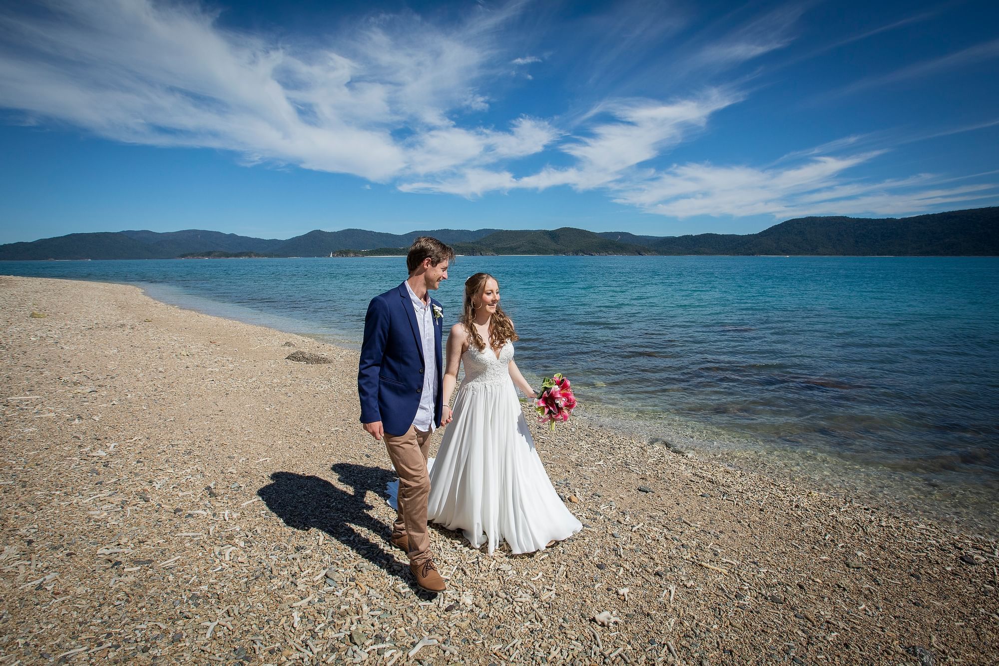 Wedded couple walking on beach at Daydream Island Resort