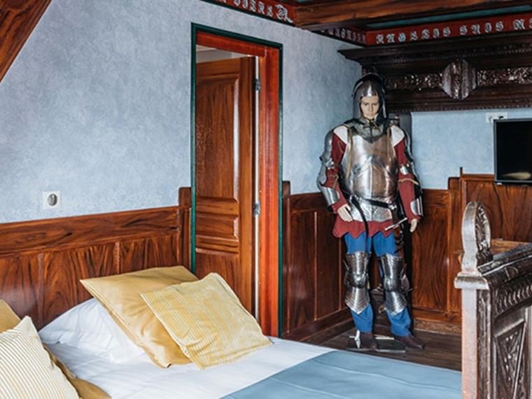 Chambre junior suite avec armure médiévale et lit douillet à Hôtel Villa Aultia, Ault.