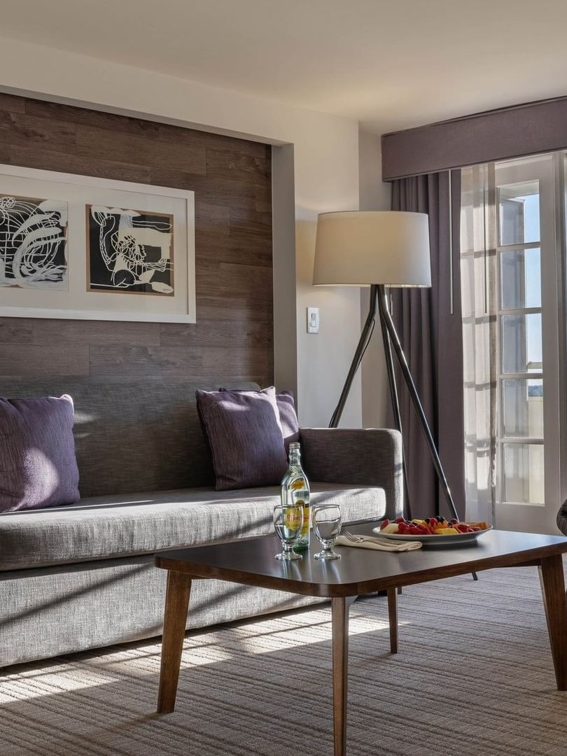 Executive Suites features Armchair by a grey sofa under a tripod lamp in a modern living area at Warwick Denver