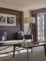 Executive Suites features Armchair by a grey sofa under a tripod lamp in a modern living area at Warwick Denver