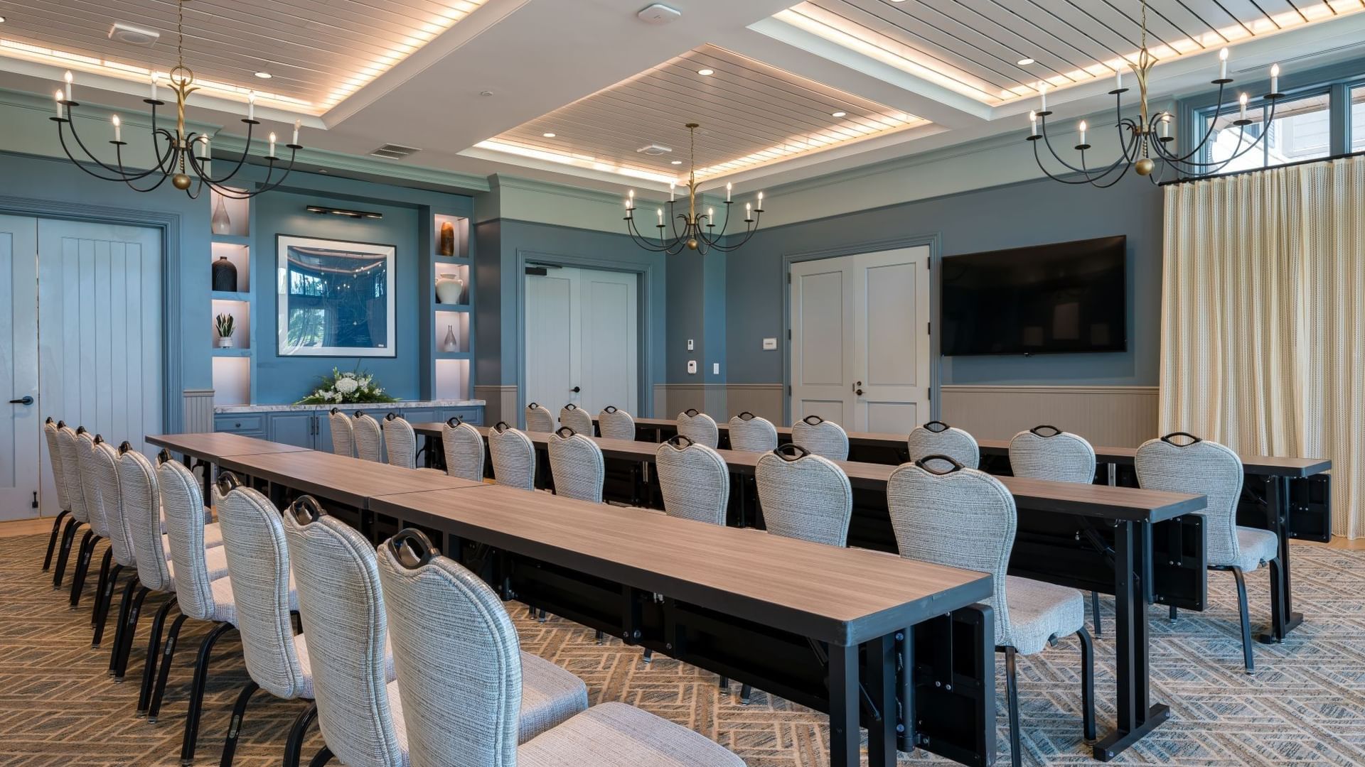 Spacious Club Room with long conference tables, upholstered chairs, and elegant chandeliers at Camp Creek Inn in Inlet Beach.