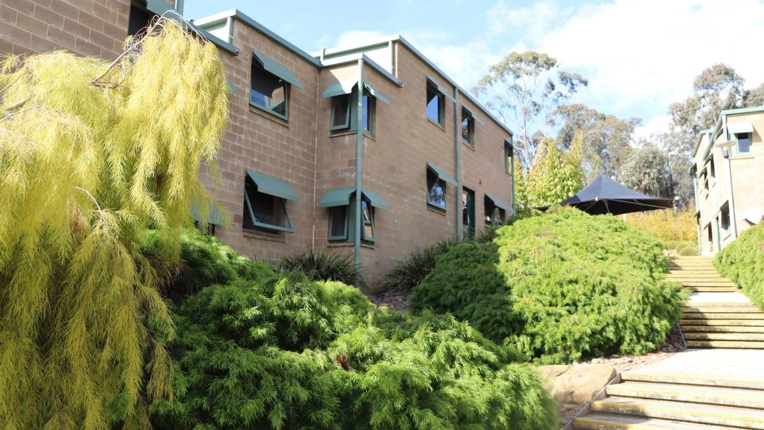 Stairs leading to La Trobe University - Units building with lush greenery.