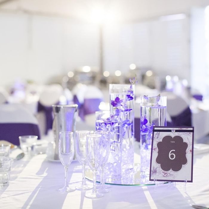 Elegant wedding table set with white & purple accents and soft lighting at Mercure Hotel Townsville