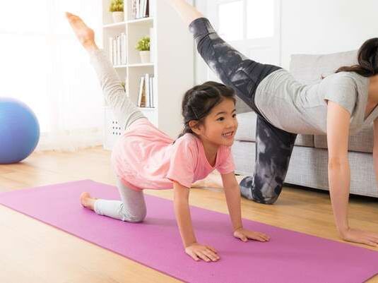 A kid and a adult doing yoga at Clinton Hotel South Beach