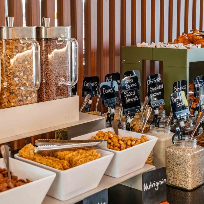 Assortment of nuts, dried fruits, and cereals labeled for selection at Buffet Breakfast in Mercure Kooindah Waters