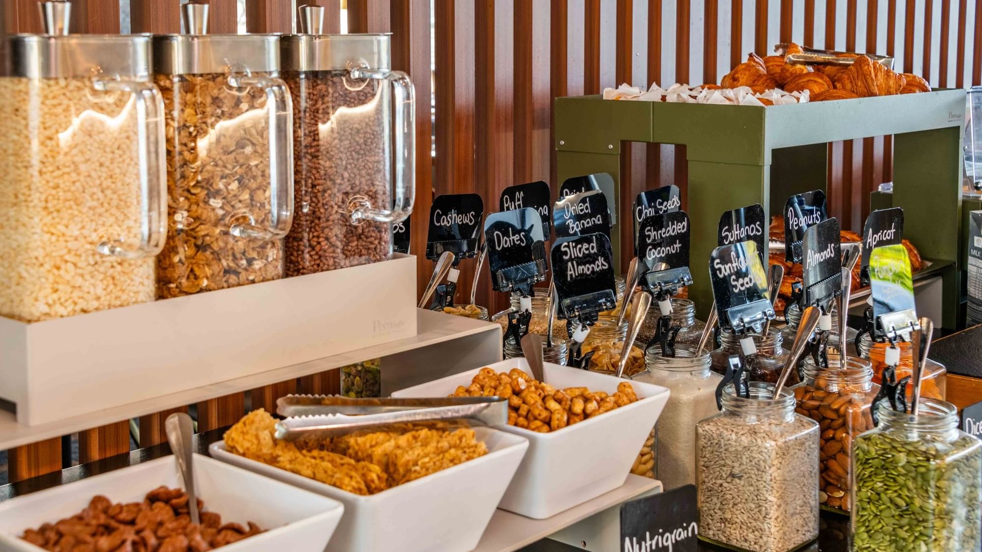 Assortment of nuts, dried fruits, and cereals labeled for selection at Buffet Breakfast in Mercure Kooindah Waters