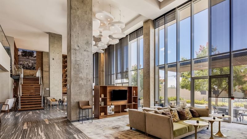 Modern lobby featuring concrete pillars, large windows and stylish furnishing at Fiesta Inn Suites Aeropuerto del Bajío