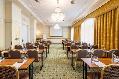 Classroom table set-up and a projector screen in a meeting room at Polonia Palace Hotel