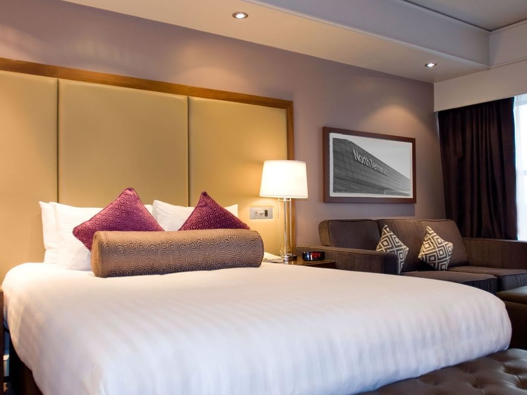 The King Room at Sandman Signature London Gatwick Hotel with one king bed (with premium pillow-top) and a 3 seater sofa on the side of the bed next to the window