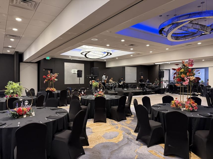 Ballroom with decorated banquets facing project screen at APA Hotel Woodbridge