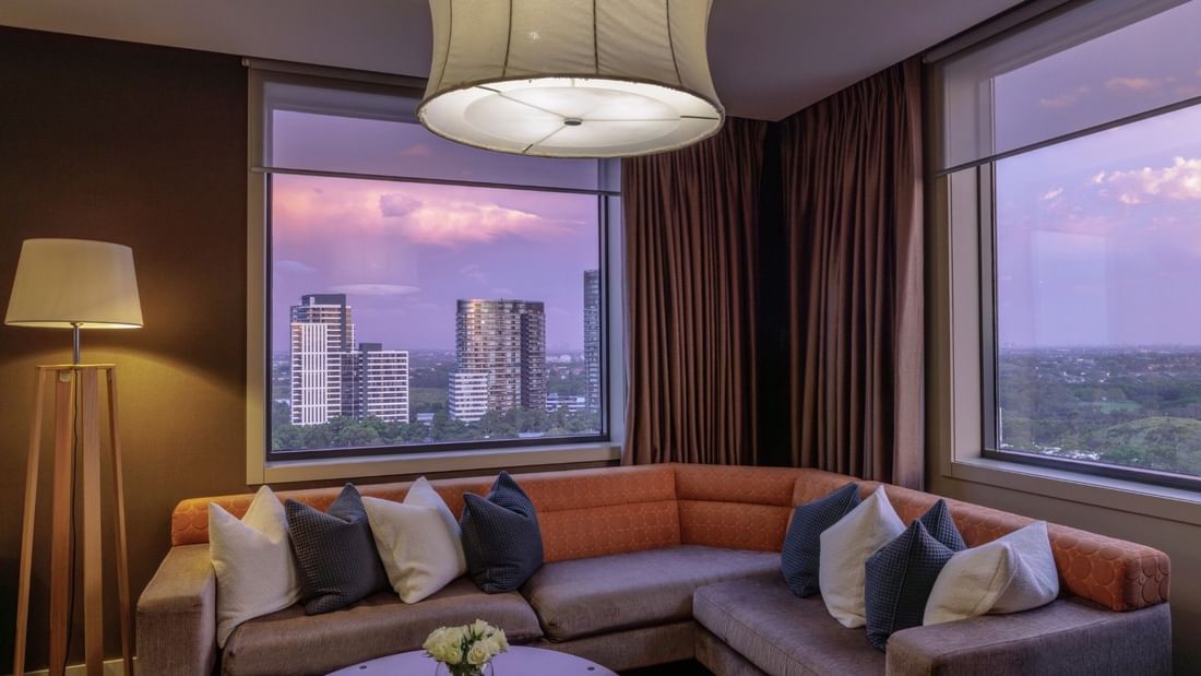 Elegant lounge with city skyline view and plush seating at Pullman Sydney Olympic Park.