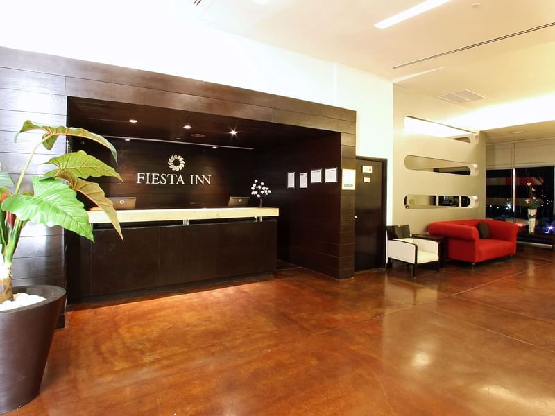 Reception counter with the lobby area at Fiesta Inn Hotels