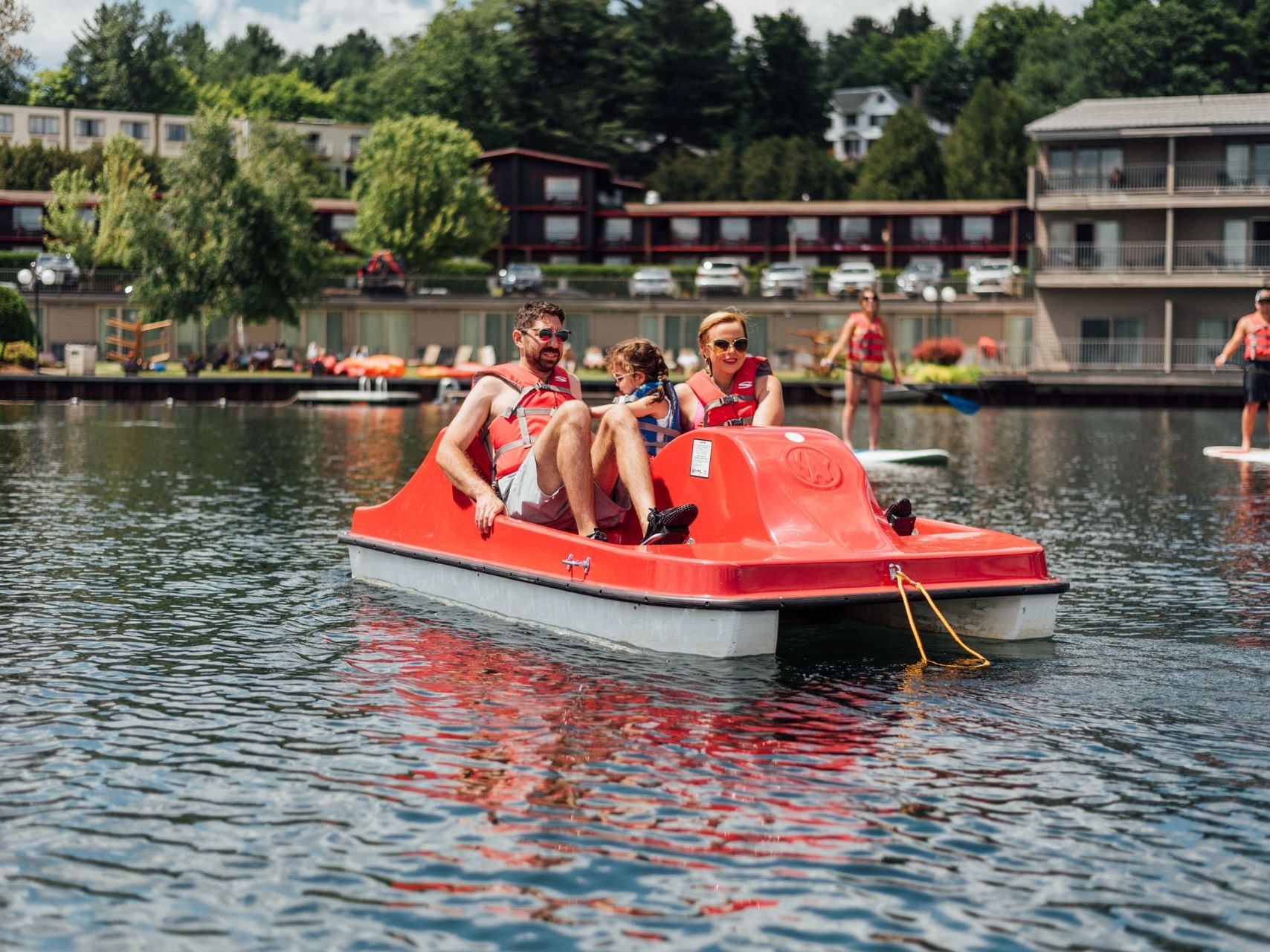 A family enjoying a pedalboat ride at a lake near High Peaks Resort