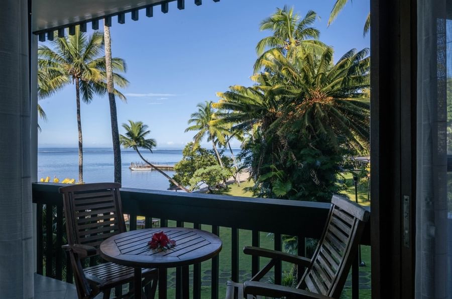 Wooden chairs by a table under a dark ceiling in Double Double Ocean View Terrace at Warwick Fiji Resort and Spa