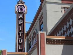 Low-angle view of Capitol Theatre exterior with sign near Retro Suites Hotel