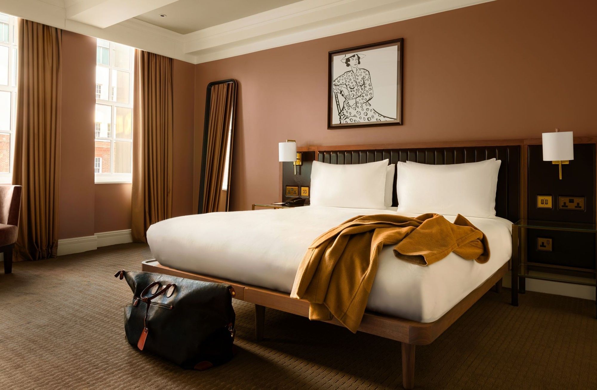 Collection Premium room with a large king bed, with jacket on the bed and overnight bag - showcasing someone staying.