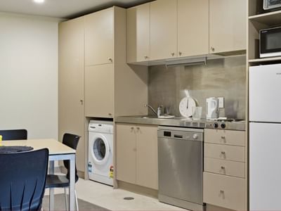 Modern kitchen with appliances and dining table in UniLodge Stafford House.