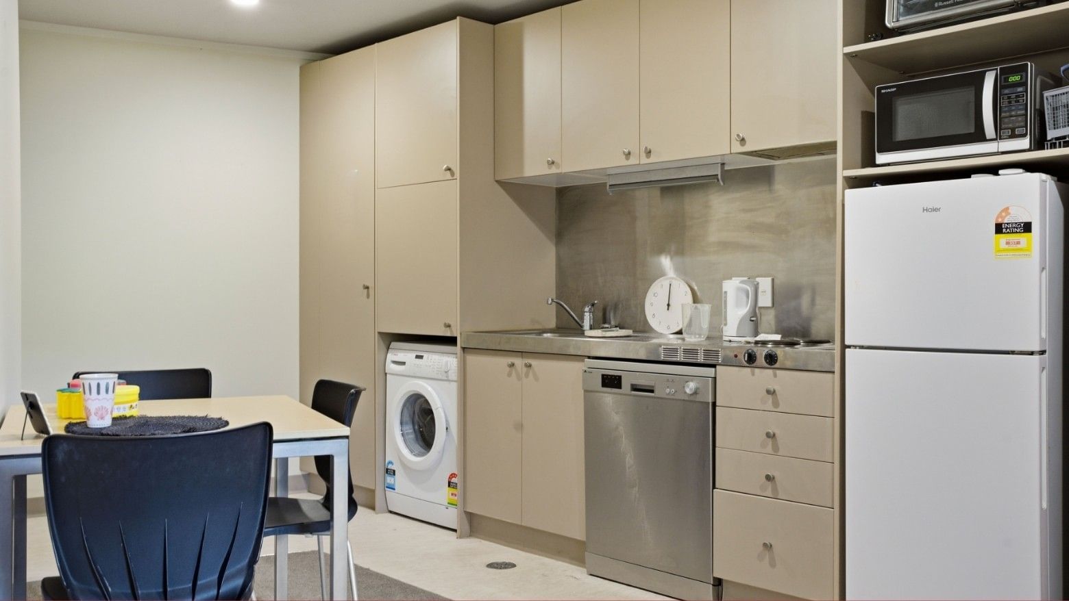 Modern kitchen with appliances, dining table, and storage at UniLodge Stafford House.