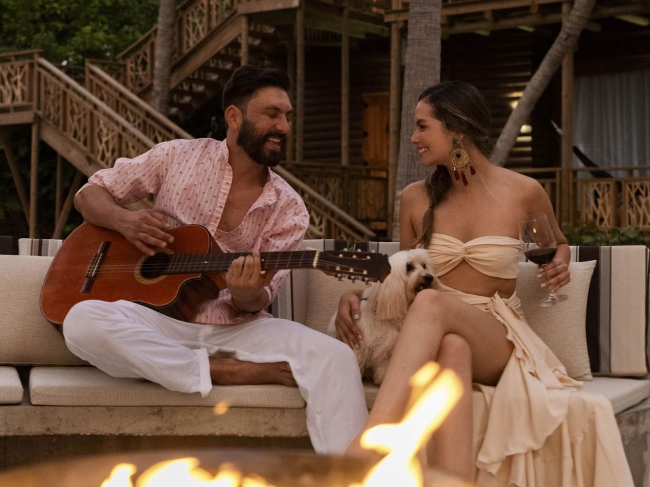 A couple enjoying singing while sitting near the fire pit at Hotel Isla Del Encanto