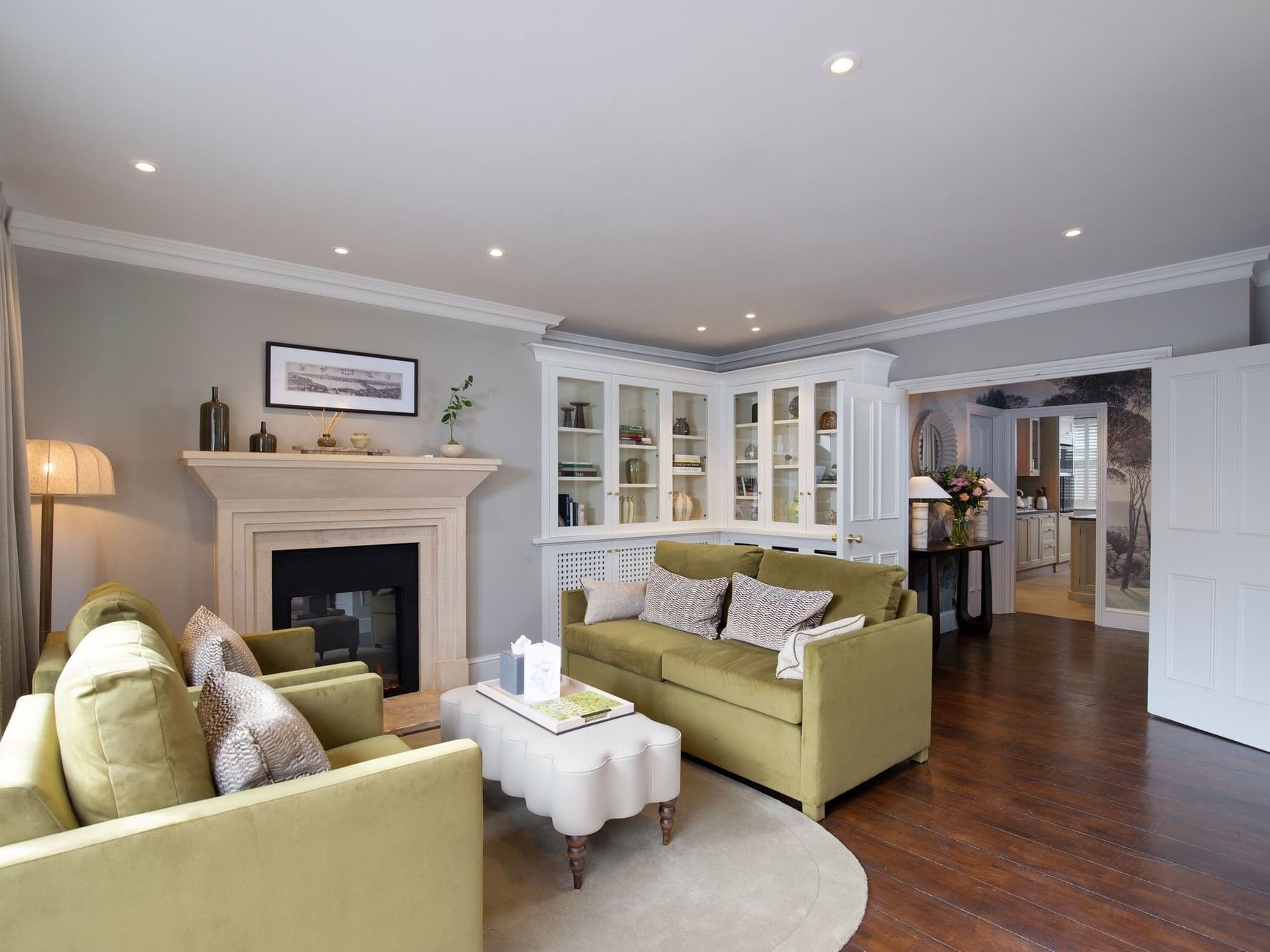 Elegant living room with green couches, fireplace, and wooden floors at The Capital Hotel, Apartments & Townhouse in London.