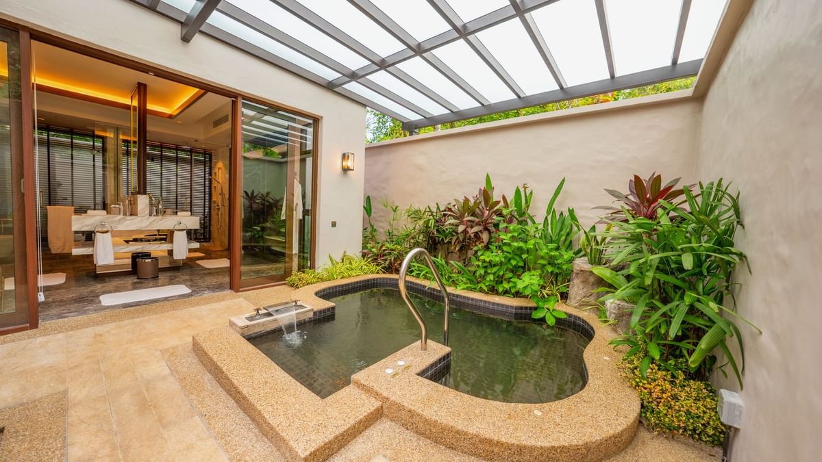 Private outdoor hot spring pool with glass roof and tropical plants in Grand Garden Villa at The Banjaran Hotsprings Retreat