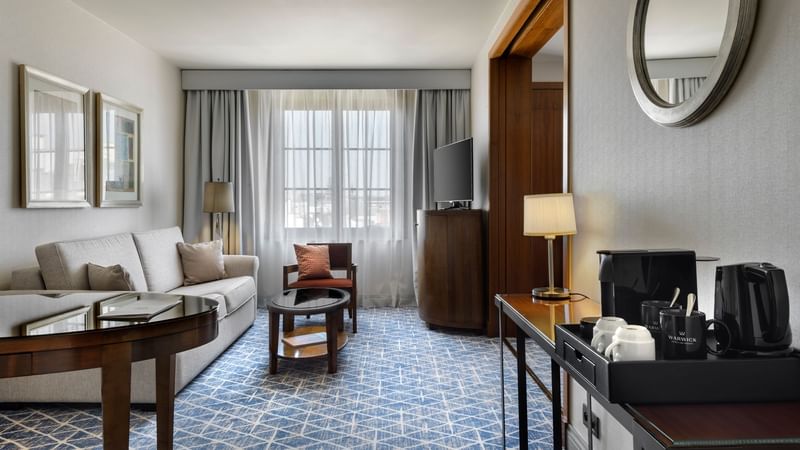 Seating area with TV and coffee station in Warwick Suite at Warwick Brussels