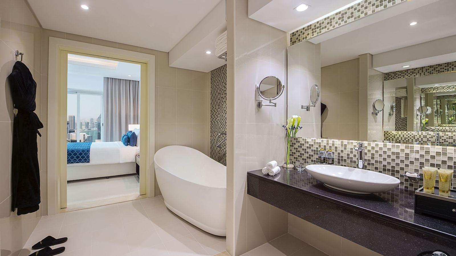 Bathroom vanity, bathtub with bathrobes in Three Bedroom Suite at DAMAC Maison Distinction