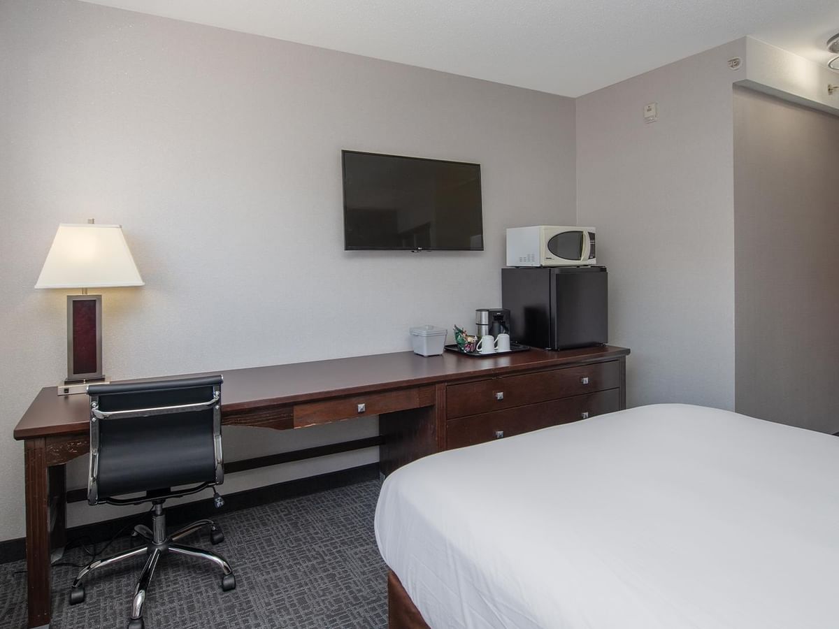 Room with desk, chair, and TV.