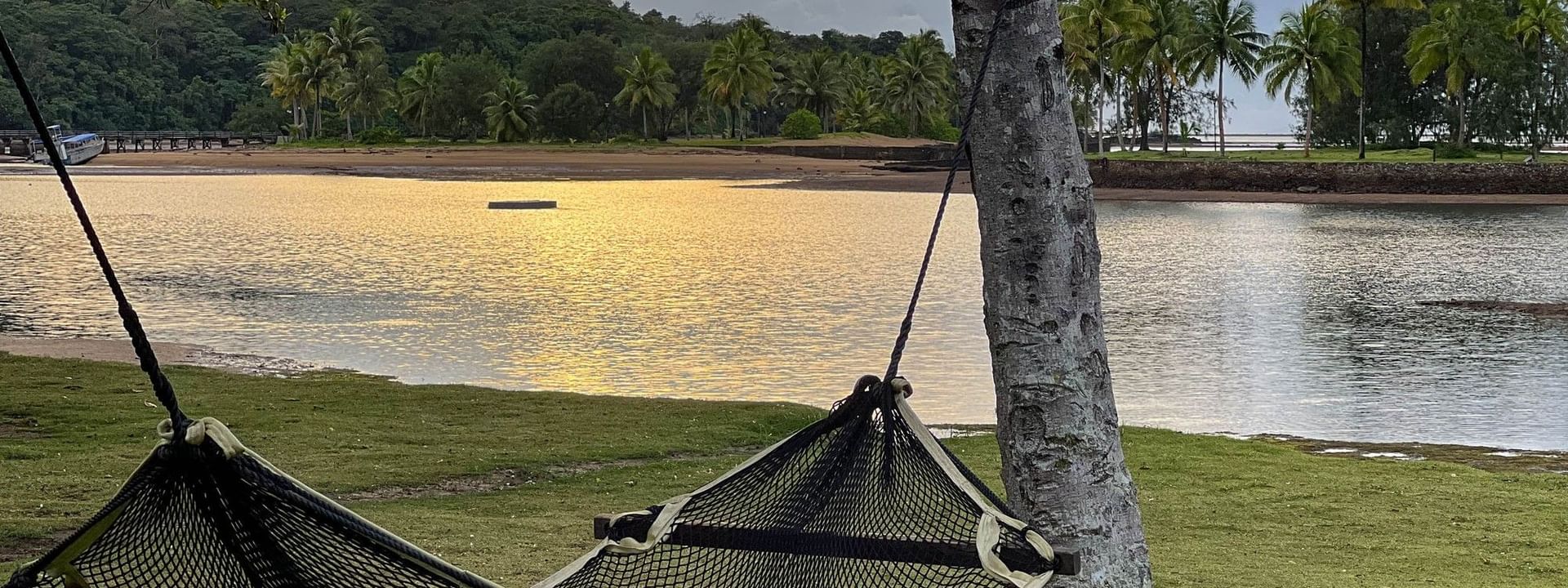 Hammock on grass overlooking a beach at sunset at The Naviti Resort in Korolevu Fiji