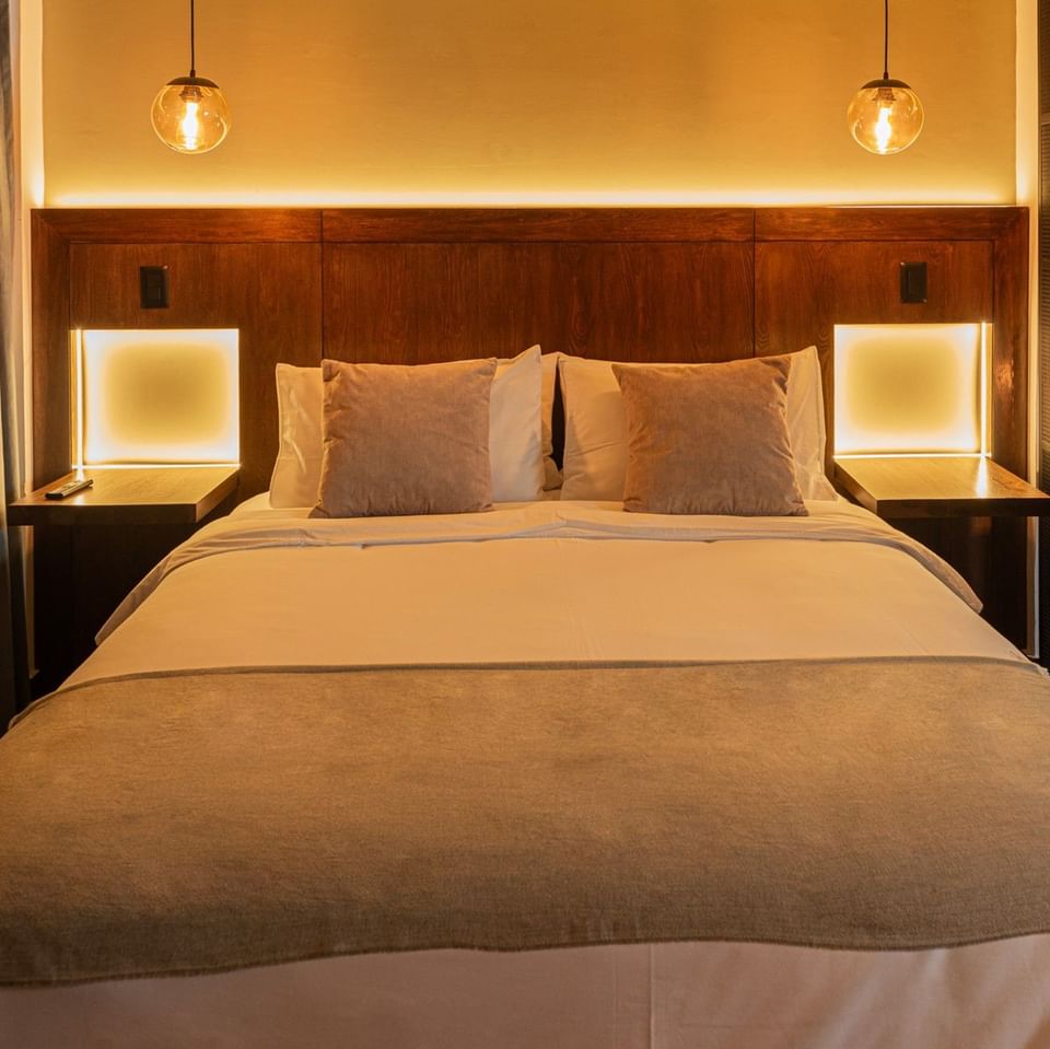 Stylish Studio bedroom with soft lighting, pendant lamps, cozy bedding and warm tones offering comfort at 5Q House Zona G