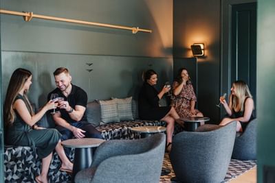 Guests toasting with their wine glasses while smiling in Restaurant at The Stonebreaker Hotel