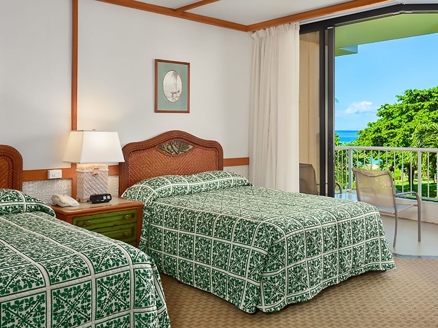 two beds in hotel room with view of tropical setting