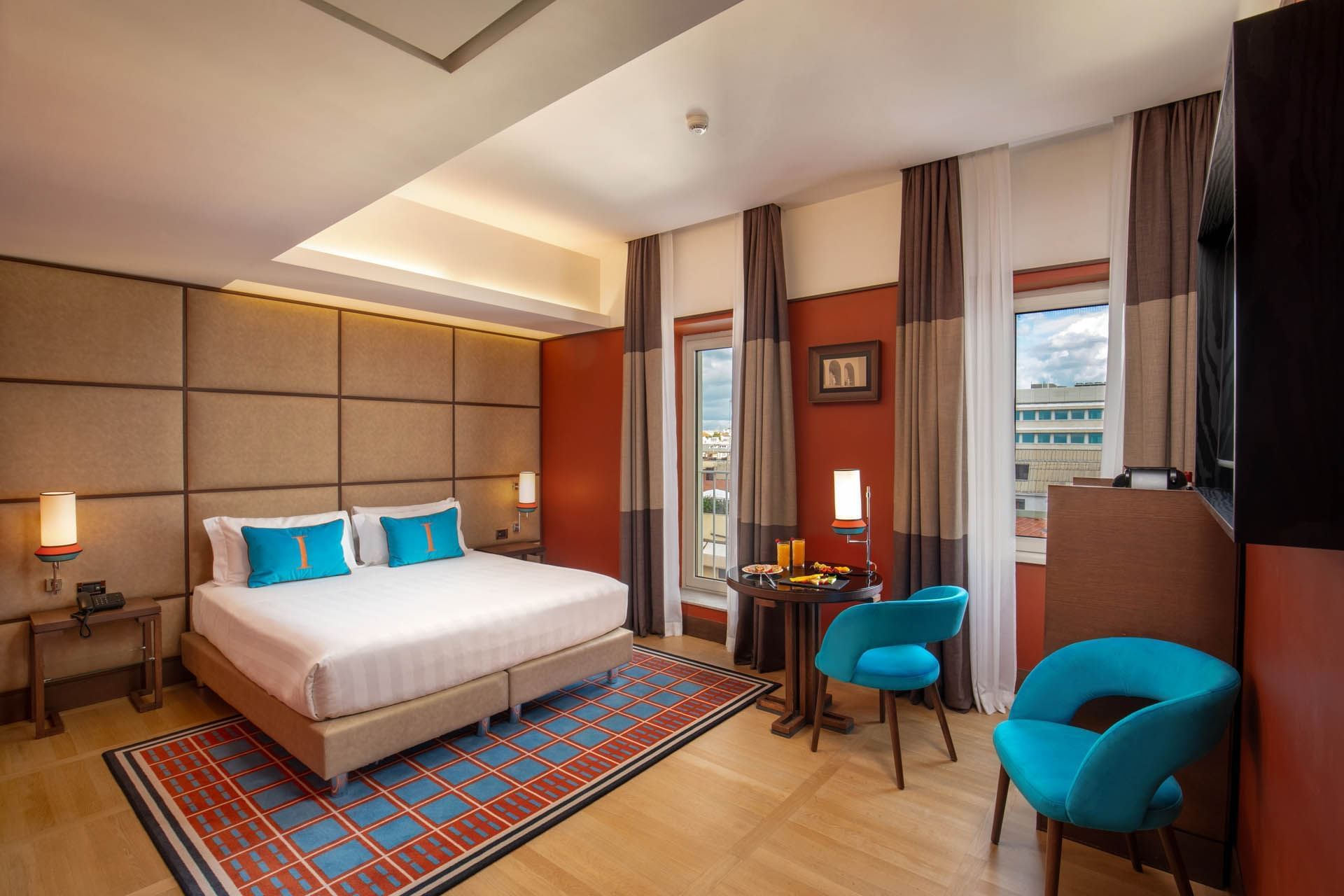Modern Superior Room with a plush bed, wooden floors, and cozy seating by the window at The Independent