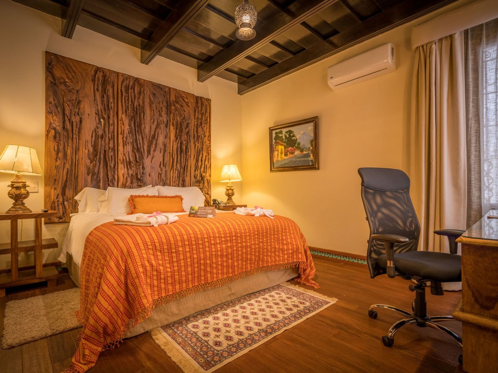 King bed & work desk in Master Suite with wooden floors at Pensativo House Hotel