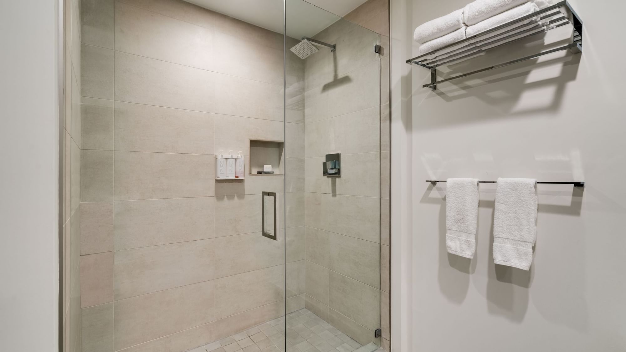 A modern bathroom shower with glass door and tiled walls