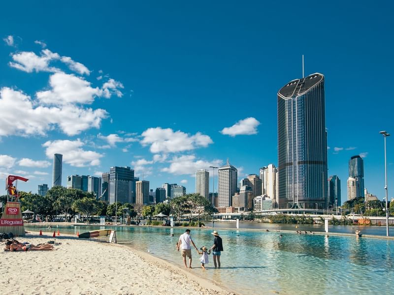 City skyline view from a beach with people at South Bank near Sofitel Brisbane Central