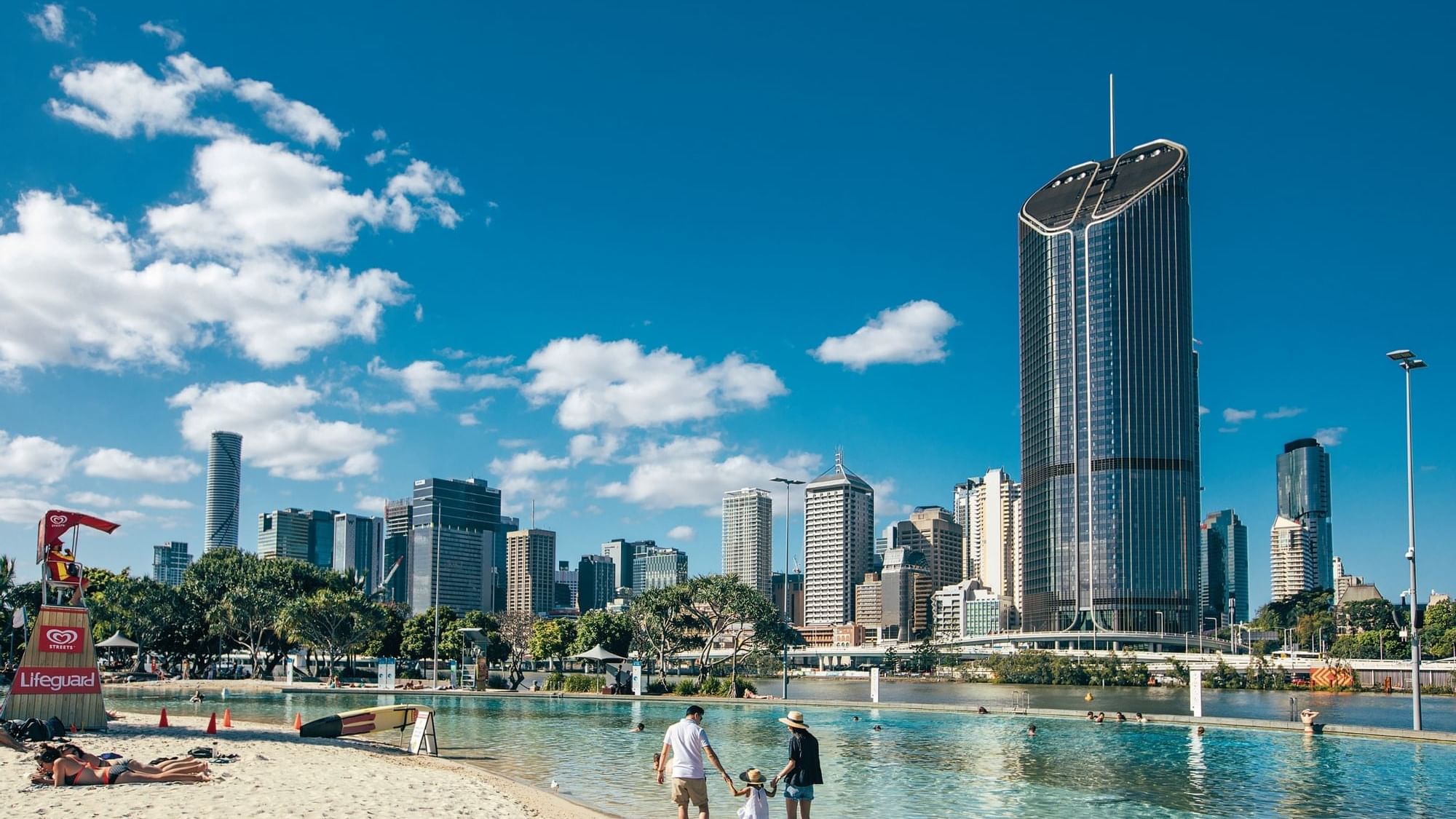 City skyline view from a beach with people at South Bank near Sofitel Brisbane Central
