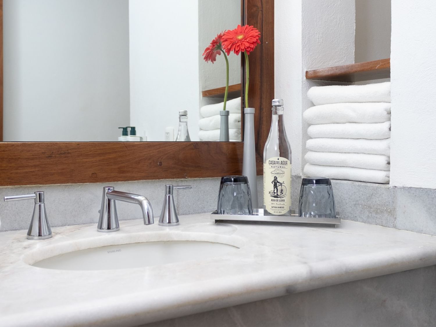 Baño elegante con espejo, toallas y botella en Suite Gobernador King de Quinta Real Oaxaca en Oaxaca de Juárez