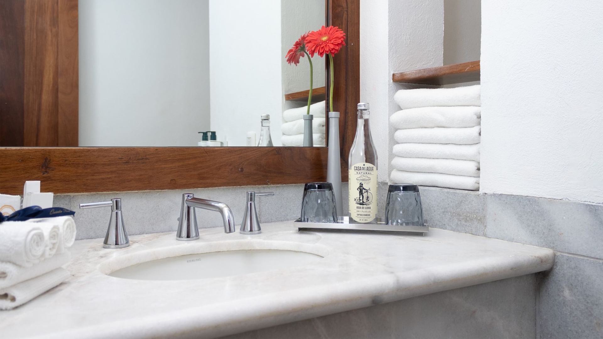 Baño elegante con espejo, toallas y botella en Suite Gobernador King de Quinta Real Oaxaca en Oaxaca de Juárez