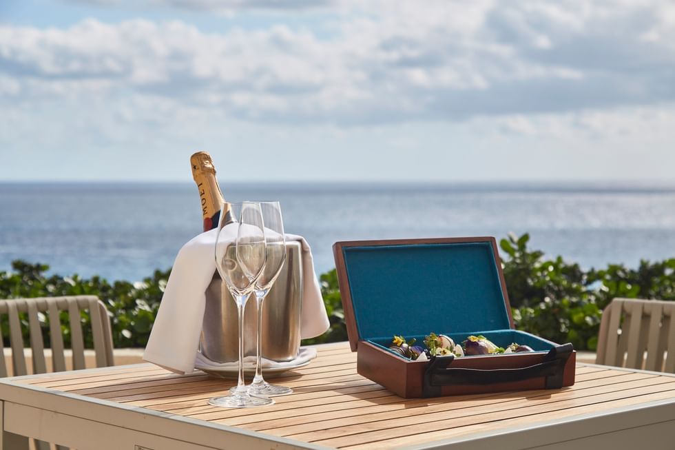 Close-up of Champagne bottle and glasses on a wooden table overlooking the sea at Live Aqua Resorts and Residence Club