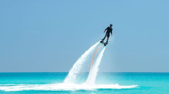 A man soaring through the air on a jet ski near Grand Park Kodhipparu, Maldives