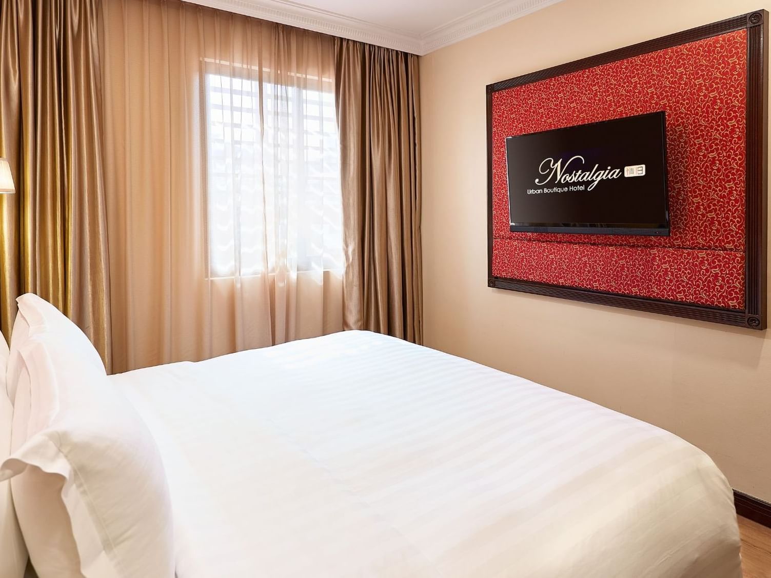 King-size bed with comfy pillows & TV Executive Room in Nostalgia Hotel Singapore